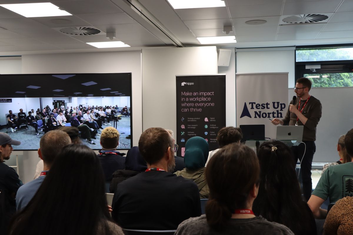 The room from the back, with the camera's live view of the audience on the screen at the front